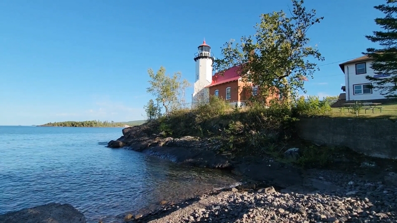 Eagle Harbor Lighthouse stands on a rocky Lake Superior shoreline