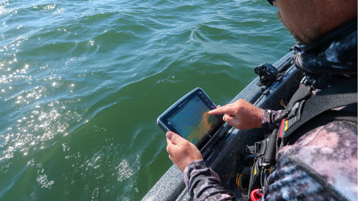 Angler using a sonar device on a boat to check thermocline depth